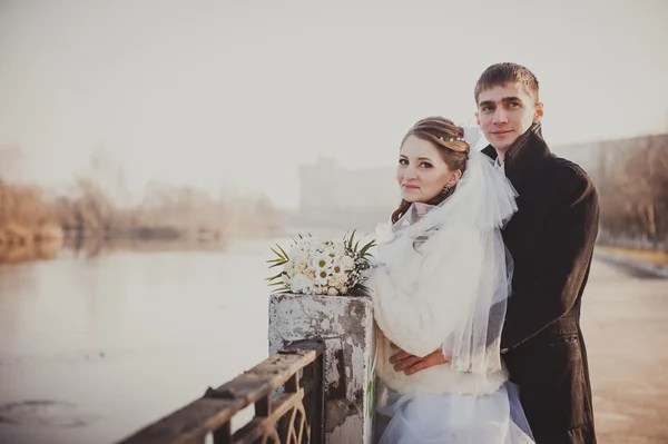 Nevěsta a ženich objímání na břehu jezera v parku. Svatba moři. Líbánky. — Stock fotografie