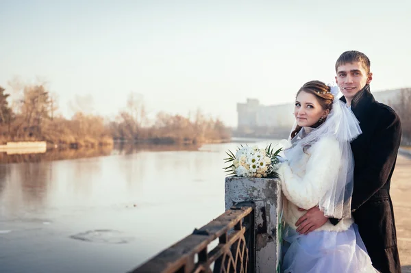 The bride and groom hugging on shore of Lake in a park. Wedding by the sea. Honeymoon. — Stock Photo, Image