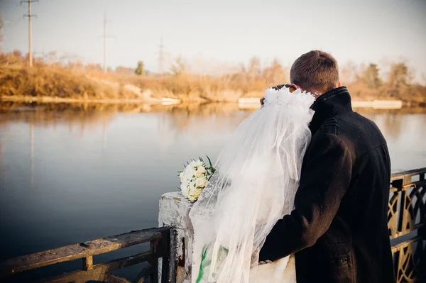 The bride and groom hugging on shore of Lake in a park. Wedding by the sea. Honeymoon. — Stock Photo, Image