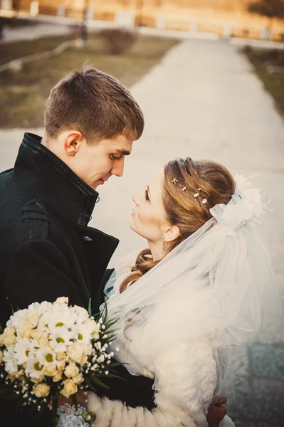 Elegantní nevěsta a ženich pózují spolu venku ve svatební den — Stock fotografie