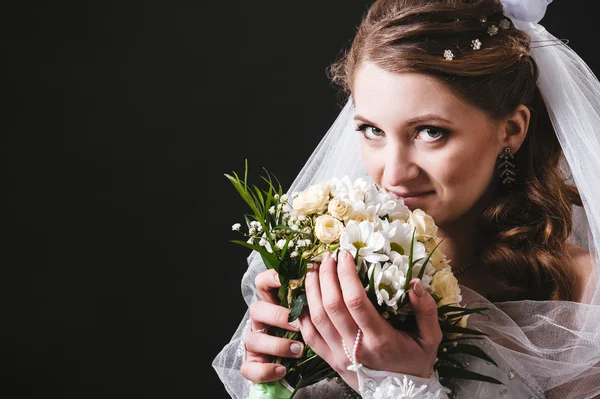 Modelo de moda com buquê de noiva bebendo champanhe e vestindo vestido de noiva no fundo do estúdio preto — Fotografia de Stock