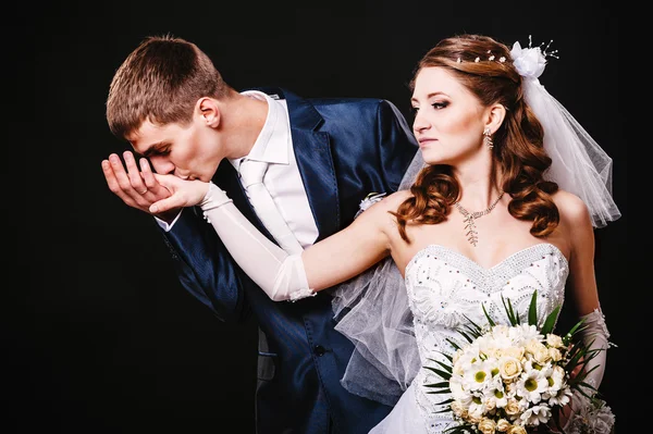 Novia y novio besándose, abrazándose. foto de boda tomada en el estudio sobre fondo negro —  Fotos de Stock