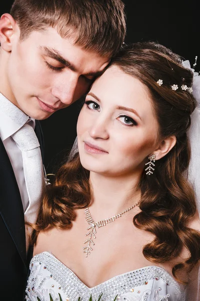 Novia y novio besándose, abrazándose. foto de boda tomada en el estudio sobre fondo negro —  Fotos de Stock