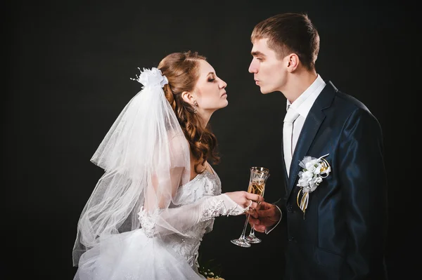 Casamento casal beijando e bebendo champanhe. Fundo preto . — Fotografia de Stock