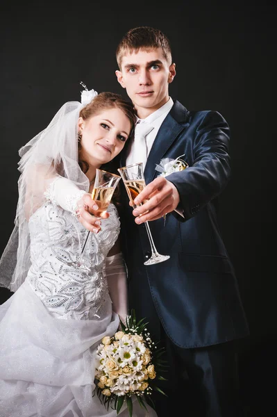 Bröllop par kyssar och dricka champagne. Svart bakgrund. — Stockfoto