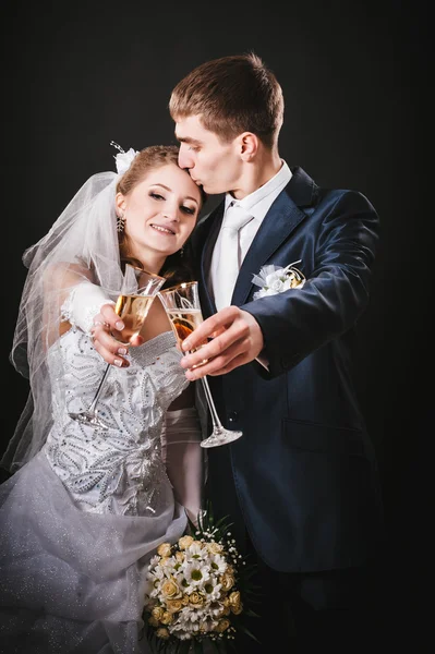 Wedding couple kissing and drinking champagne. Black background. — Stock Photo, Image