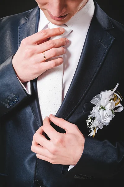 Ręce ślubu pary młodej przygotowuje się w garnitur. czarny studio tło — Zdjęcie stockowe