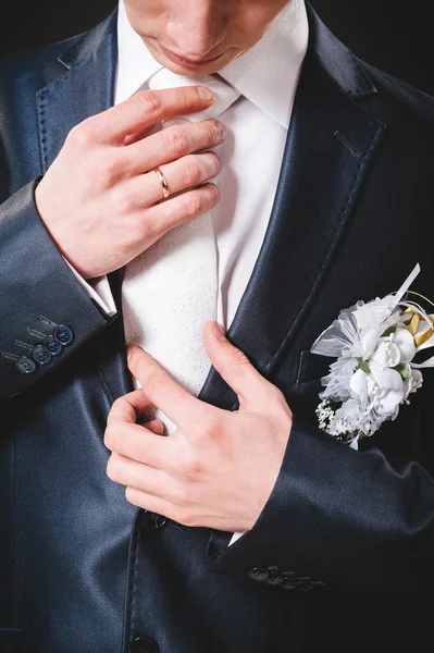 Ręce ślubu pary młodej przygotowuje się w garnitur. czarny studio tło — Zdjęcie stockowe