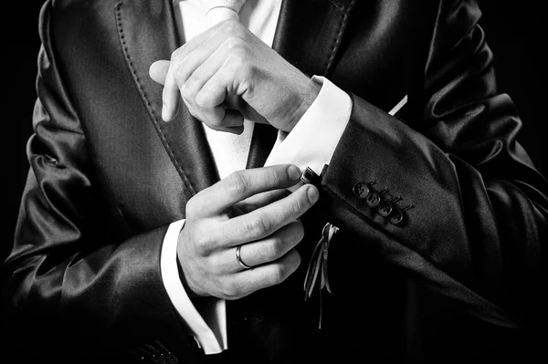 Hands of wedding groom getting ready in suit. black studio background — Stock Photo, Image