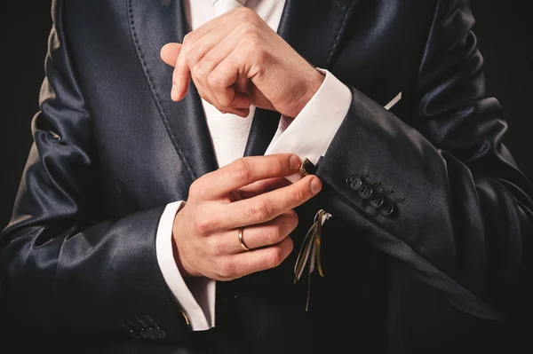 Las manos del novio de boda preparándose en traje. fondo negro estudio — Foto de Stock