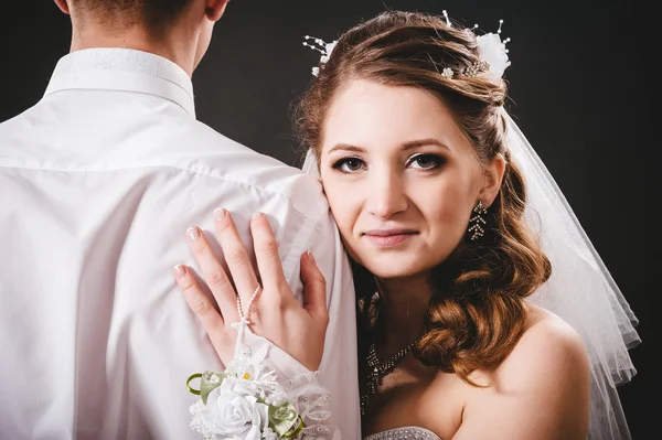 Groom kissing bride on wedding. Black background. — Stock Photo, Image