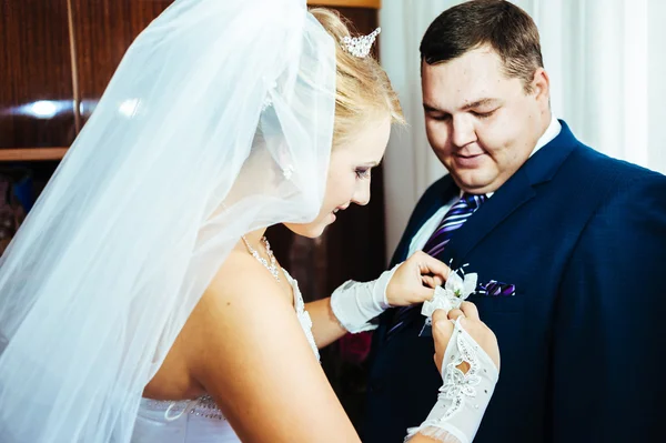 Brides hand putting the boutonniere flower on  groom — Stock Photo, Image