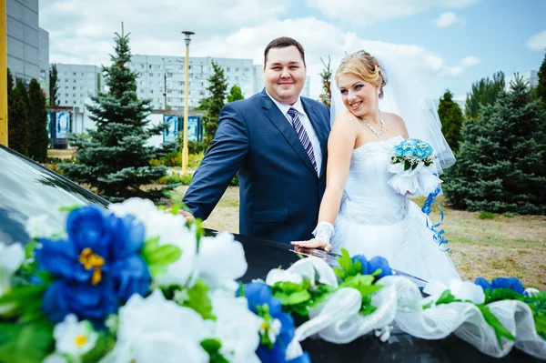 Felice sposo aiutare la sua sposa fuori dalla macchina di nozze . — Foto Stock