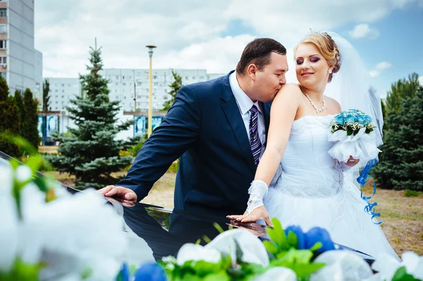 Šťastný ženich pomáhá jeho nevěsta ze svatební auta. — Stock fotografie