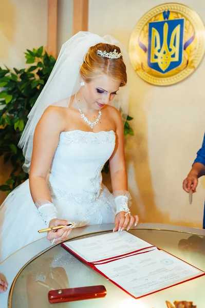 De ceremonie van het huwelijk. Kadaster. Een nieuw getrouwde paar ondertekent het huwelijk document. Jong koppel bruiloft documenten ondertekenen — Stockfoto