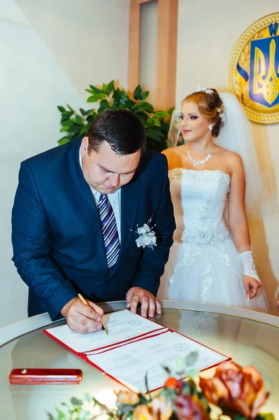 結婚式。登記所。新婚カップルの結婚ドキュメントに署名します。若いカップルの結婚式文書の署名 — ストック写真