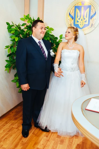 Une cérémonie de mariage. Bureau du greffe. Un couple nouvellement marié signe le document de mariage.Jeune couple signant les documents de mariage — Photo