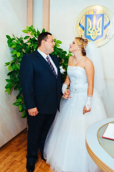 Une cérémonie de mariage. Bureau du greffe. Un couple nouvellement marié signe le document de mariage.Jeune couple signant les documents de mariage — Photo