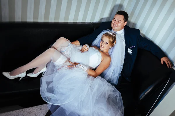 Affascinanti sposi durante la loro celebrazione di nozze in un lussuoso ristorante. Bouquet da sposa di fiori e abito da sposa. coppia appena sposata nel lussuoso hotel moderno hall — Foto Stock