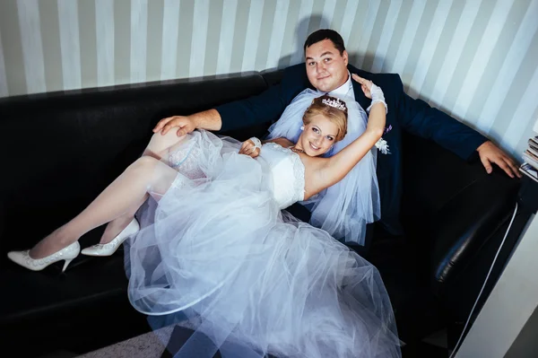 Charming bride and groom on their wedding celebration in a luxurious restaurant. Wedding bouquet of flowers and bridal dress. newly married couple in luxury modern hotel hall — Stock Photo, Image