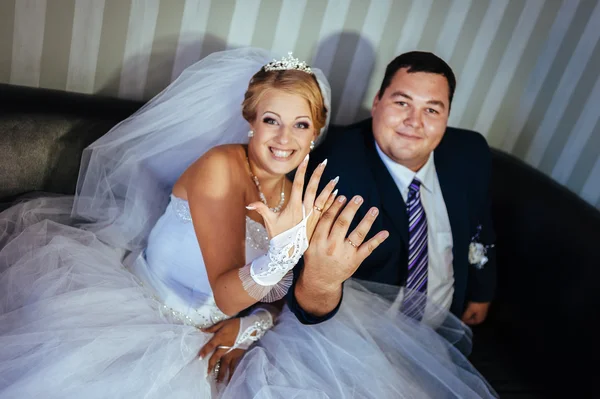 Encantadores novios en la celebración de su boda en un lujoso restaurante. Ramo de flores y vestido de novia. pareja de recién casados en el lujoso hotel moderno hall —  Fotos de Stock