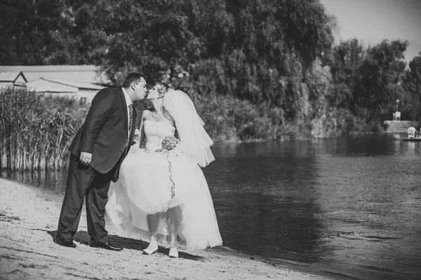 Iubitor cuplu de nunta de mers pe jos și sărutându-se lângă apă — Fotografie, imagine de stoc