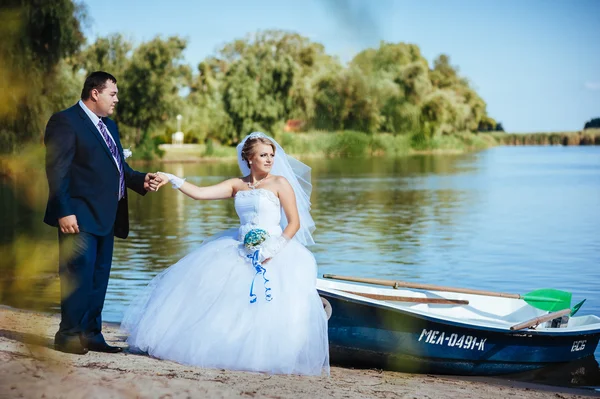 Amor casamento casal andando e beijando perto da água — Fotografia de Stock