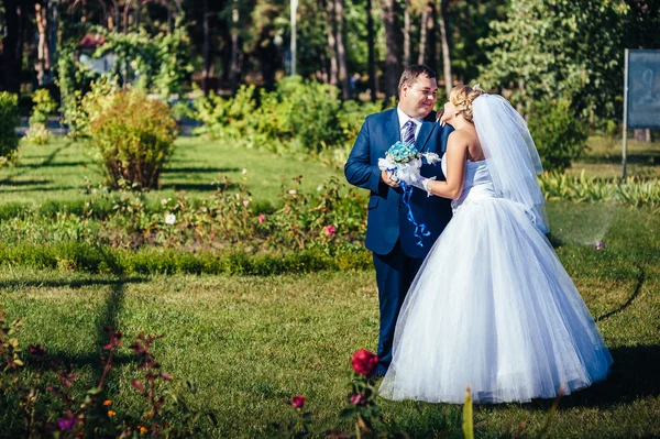 Gelin ve damat gün açık havada yürüyüş düğününde Doğa bahar. Gelin çift, mutlu yeşil park kucaklayan yeni evliler. — Stok fotoğraf