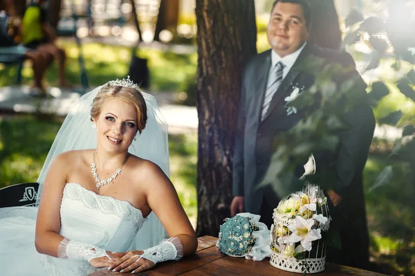 Noiva e noivo no dia do casamento andando ao ar livre na natureza de primavera. Casal nupcial, mulher recém-casada feliz e homem abraçando no parque verde. Casal de amor ao ar livre — Fotografia de Stock