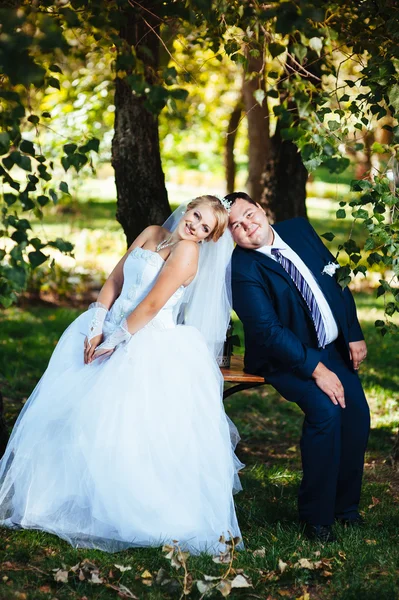 Noiva e noivo no dia do casamento andando ao ar livre na natureza de primavera. Casal nupcial, mulher recém-casada feliz e homem abraçando no parque verde. Casal de amor ao ar livre — Fotografia de Stock