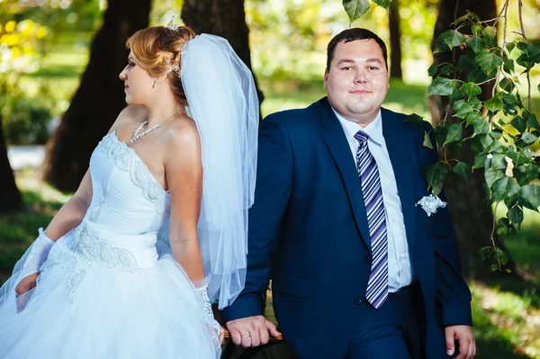 Braut und Bräutigam am Hochzeitstag beim Spaziergang in der Natur des Frühlings. Brautpaar, glückliche frisch vermählte Frau und Mann umarmen sich im grünen Park. Liebendes Hochzeitspaar im Freien — Stockfoto