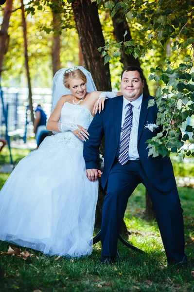 Brudparet på bröllopsdagen promenader utomhus på vår natur. Brudparet, lycklig nygift kvinna och man som omfattar i grön park. kärleksfull bröllop par utomhus — Stockfoto