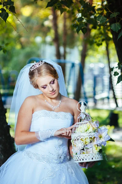 Vackra brud poserar utomhus i parken i hennes bröllopsdag — Stockfoto