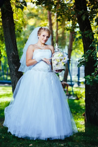 Vackra brud poserar utomhus i parken i hennes bröllopsdag — Stockfoto