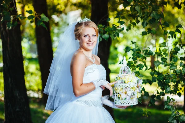 Vackra brud poserar utomhus i parken i hennes bröllopsdag — Stockfoto