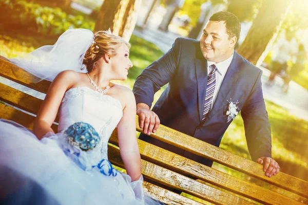 Happy bride and groom swinging on a swing in the park — Stock Photo, Image