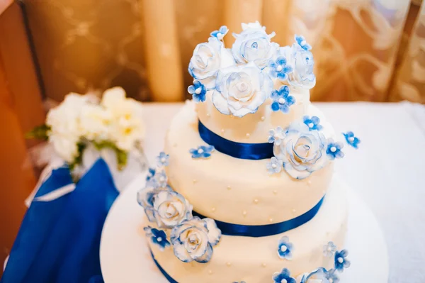 Multi level white wedding cake on silver base and pink flowers at top — Stock Photo, Image