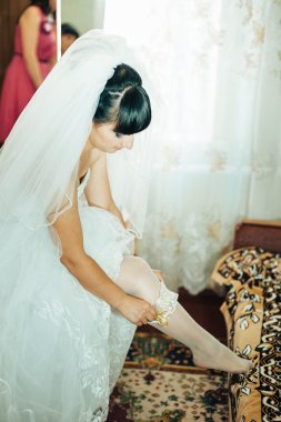 parlak makyaj ve saç modeli ile giysi güzel gelin beyaz gelinlik içinde hazırlanıyor. Damat için bekleyen mutlu seksi kız. Gelin elbiseli romantik Bayan var düğün için son hazırlık ve sunuş.