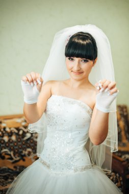 parlak makyaj ve saç modeli ile giysi güzel gelin beyaz gelinlik içinde hazırlanıyor. Damat için bekleyen mutlu seksi kız. Gelin elbiseli romantik Bayan var düğün için son hazırlık ve sunuş.