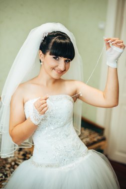 parlak makyaj ve saç modeli ile giysi güzel gelin beyaz gelinlik içinde hazırlanıyor. Damat için bekleyen mutlu seksi kız. Gelin elbiseli romantik Bayan var düğün için son hazırlık ve sunuş.