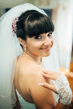 parlak makyaj ve saç modeli ile giysi güzel gelin beyaz gelinlik içinde hazırlanıyor. Damat için bekleyen mutlu seksi kız. Gelin elbiseli romantik Bayan var düğün için son hazırlık ve sunuş.