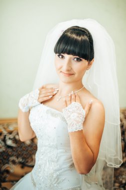 parlak makyaj ve saç modeli ile giysi güzel gelin beyaz gelinlik içinde hazırlanıyor. Damat için bekleyen mutlu seksi kız. Gelin elbiseli romantik Bayan var düğün için son hazırlık ve sunuş.