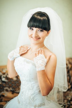parlak makyaj ve saç modeli ile giysi güzel gelin beyaz gelinlik içinde hazırlanıyor. Damat için bekleyen mutlu seksi kız. Gelin elbiseli romantik Bayan var düğün için son hazırlık ve sunuş.