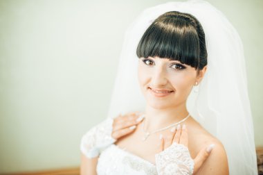 parlak makyaj ve saç modeli ile giysi güzel gelin beyaz gelinlik içinde hazırlanıyor. Damat için bekleyen mutlu seksi kız. Gelin elbiseli romantik Bayan var düğün için son hazırlık ve sunuş.