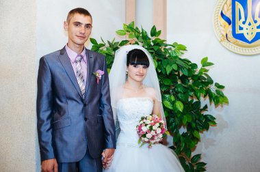 Düğün töreni. Kayıt ofisi. Bir yeni evli çift evlilik belgesi imzalar. Genç çift düğün belgelerin imzalanması.