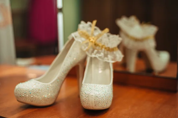 Matrimonio di lusso Eleganti scarpe da sposa e giarrettiera bianca sullo sfondo . — Foto Stock