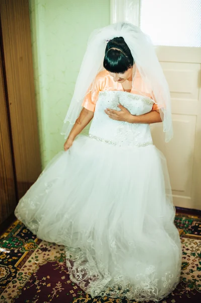 Hermosa novia preparándose en vestido de novia blanco con peinado y maquillaje brillante. Feliz chica sexy esperando al novio. Señora romántica en vestido de novia tienen la preparación final para la boda . —  Fotos de Stock