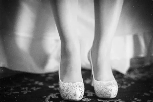 Bride is putting on her wedding shoes. — Stock Photo, Image