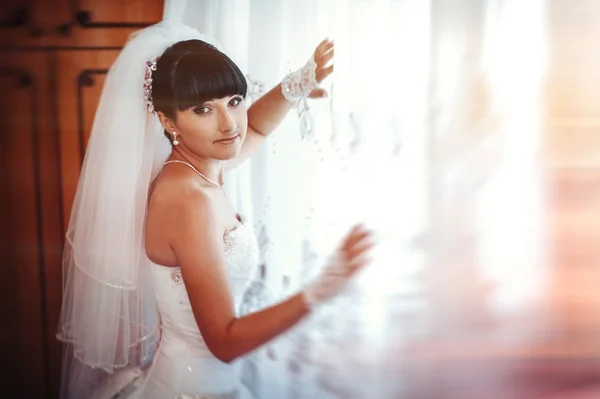 Beautiful bride getting ready in white wedding dress with hairstyle and bright makeup. Happy sexy girl waiting for groom. Romantic lady in bridal dress have final preparation for wedding. — Stock Photo, Image