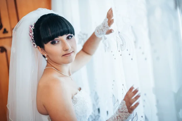 Beautiful bride getting ready in white wedding dress with hairstyle and bright makeup. Happy sexy girl waiting for groom. Romantic lady in bridal dress have final preparation for wedding. — Stock Photo, Image